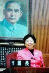 此照片顯示孫穗芳博士（Dr. Lily Sun）坐在她的祖父孫中山肖像的前面。